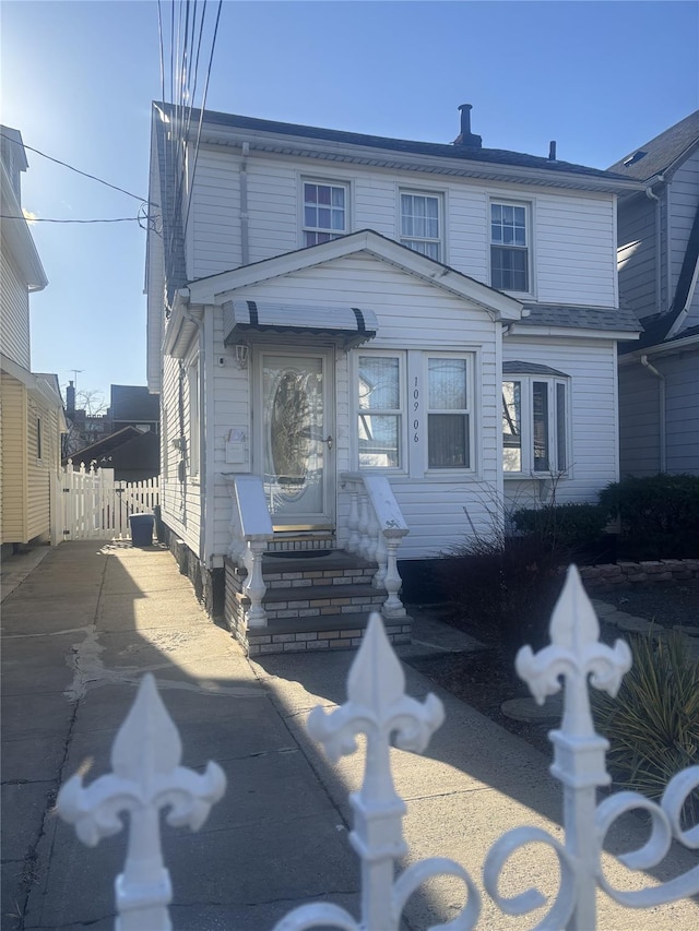 view of front facade featuring driveway and fence