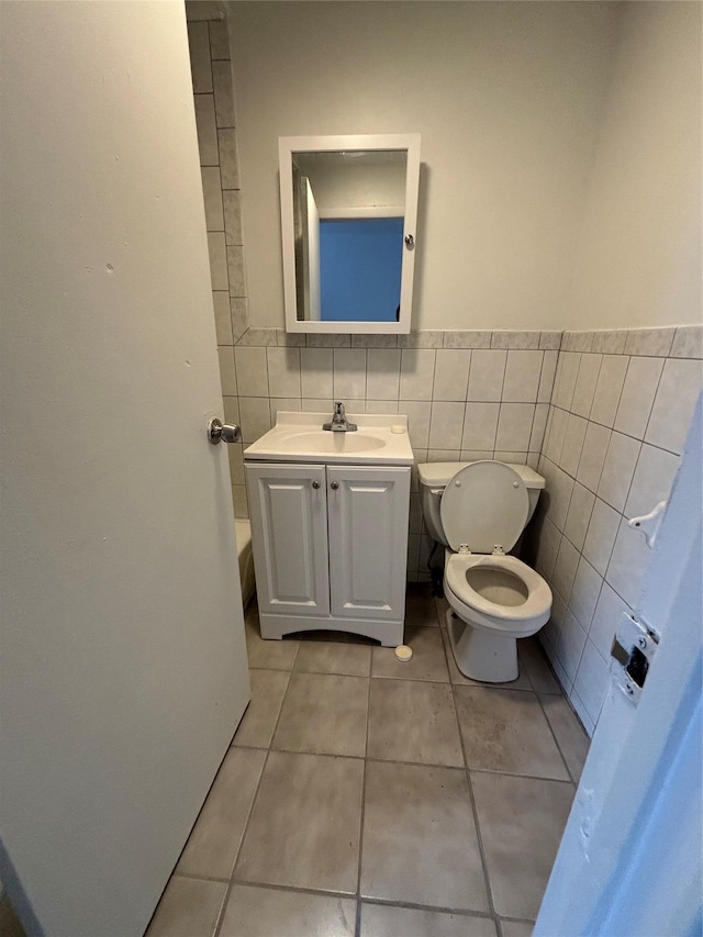 bathroom with vanity, tile walls, toilet, and tile patterned floors