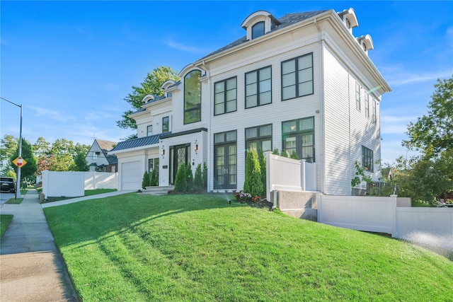 view of front facade featuring a garage, concrete driveway, a front lawn, and fence