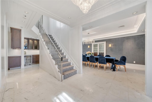 staircase featuring visible vents, marble finish floor, ornamental molding, baseboards, and a chandelier