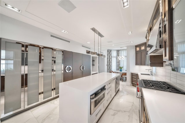 kitchen featuring a sink, stainless steel appliances, backsplash, and marble finish floor