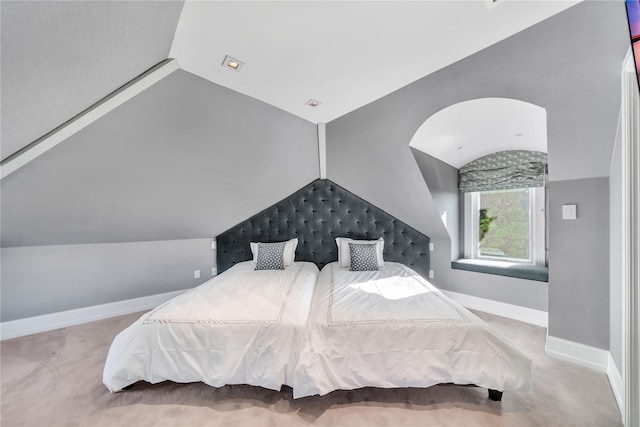 carpeted bedroom featuring baseboards and lofted ceiling