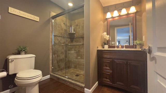 bathroom featuring a stall shower, vanity, baseboards, and wood tiled floor