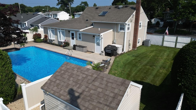 view of pool with a lawn, area for grilling, a patio, a fenced backyard, and central AC unit