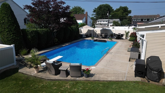 view of swimming pool with a patio area, a fenced in pool, a fenced backyard, and a diving board