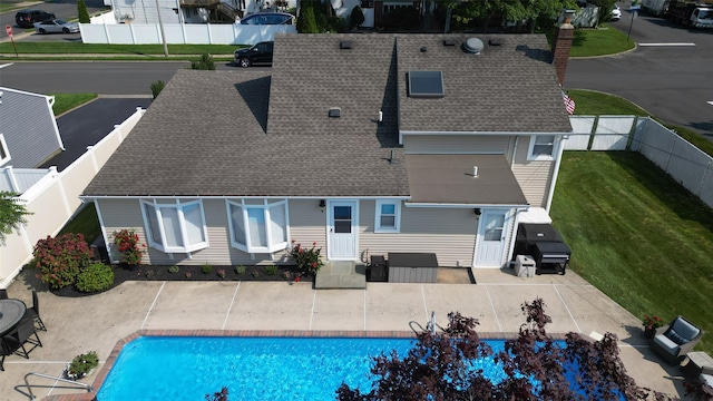 view of swimming pool featuring a yard, a patio area, a fenced in pool, and a fenced backyard