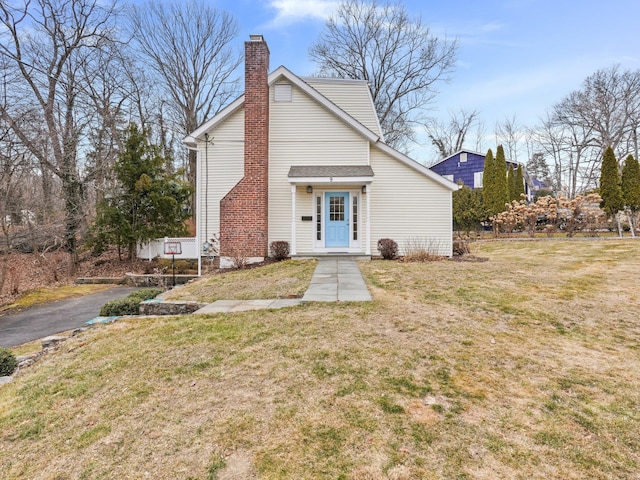 view of front of house with a front yard and a chimney