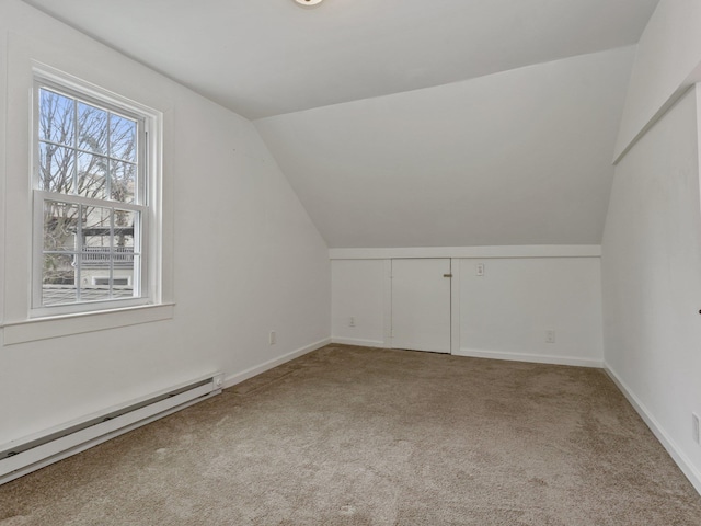 additional living space featuring baseboard heating, baseboards, lofted ceiling, and carpet