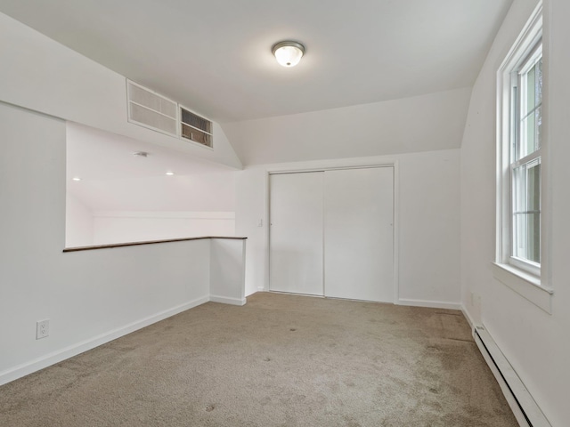 spare room with a baseboard radiator, baseboards, carpet, and visible vents