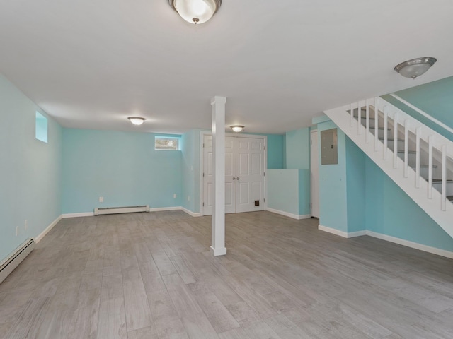 below grade area featuring a baseboard heating unit, electric panel, wood finished floors, and stairs