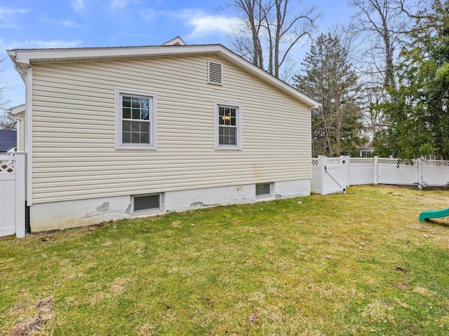 view of side of property with a gate, a yard, and fence