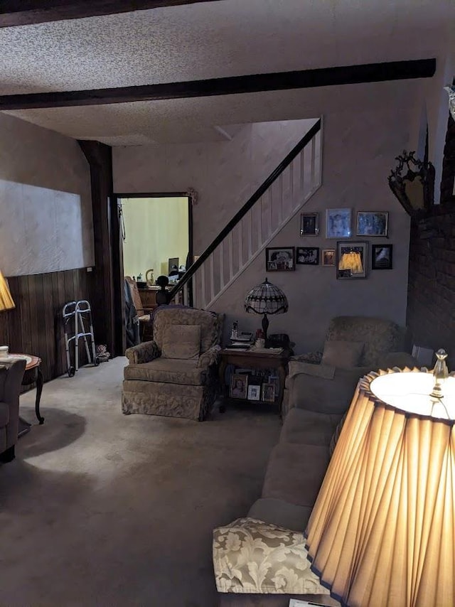 living room featuring beam ceiling, stairway, wooden walls, a textured ceiling, and concrete flooring