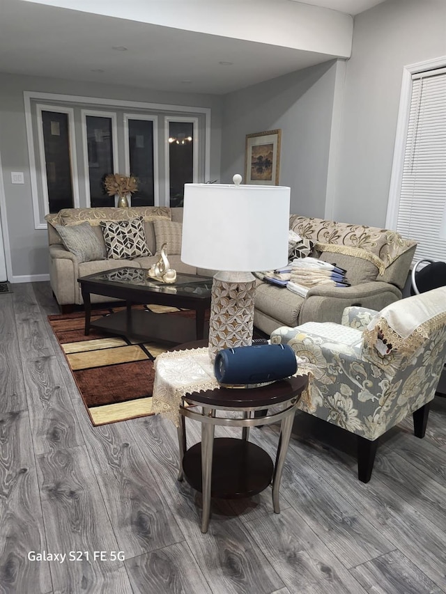 living area with baseboards and wood finished floors