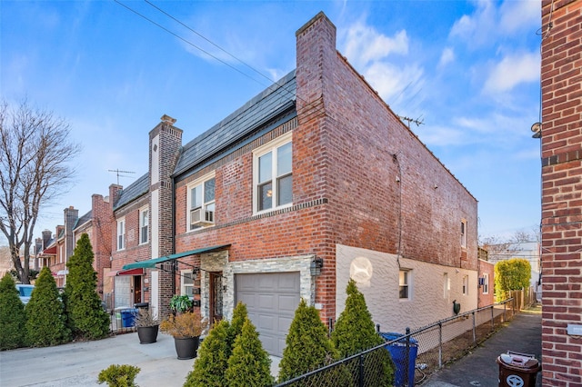 view of property exterior featuring brick siding, a high end roof, an attached garage, and fence