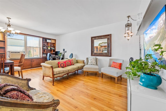 living area featuring a chandelier, cooling unit, and light wood-type flooring