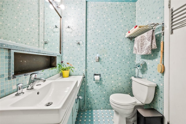 bathroom with tile patterned floors, toilet, tile walls, and vanity