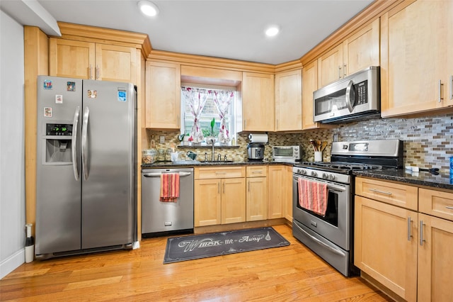 kitchen with light wood-type flooring, appliances with stainless steel finishes, and light brown cabinets