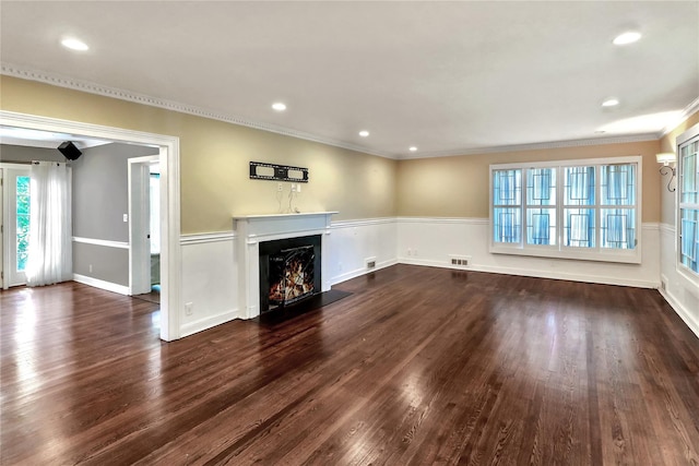 unfurnished living room featuring recessed lighting, dark wood-type flooring, a fireplace with flush hearth, visible vents, and ornamental molding