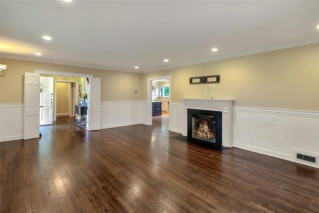 unfurnished living room featuring a fireplace with flush hearth, visible vents, dark wood finished floors, and ornamental molding