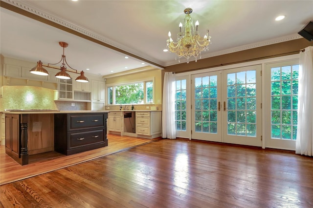 kitchen featuring light wood finished floors, light countertops, backsplash, white cabinets, and dishwasher