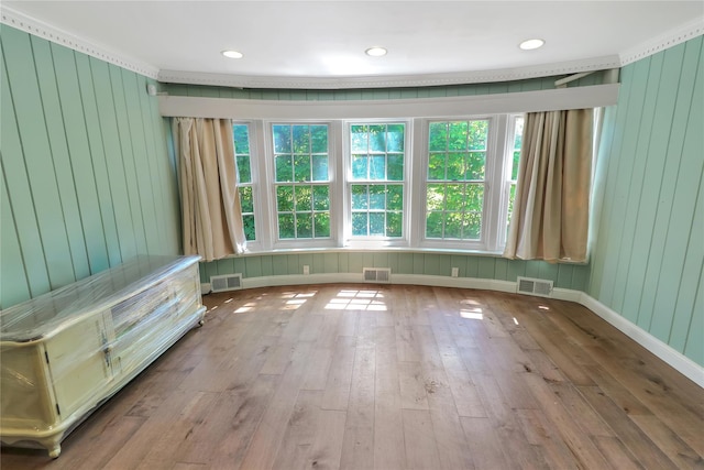 spare room with visible vents, baseboards, and hardwood / wood-style flooring