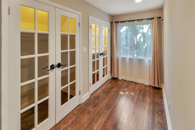 entryway with french doors, dark wood finished floors, and baseboards