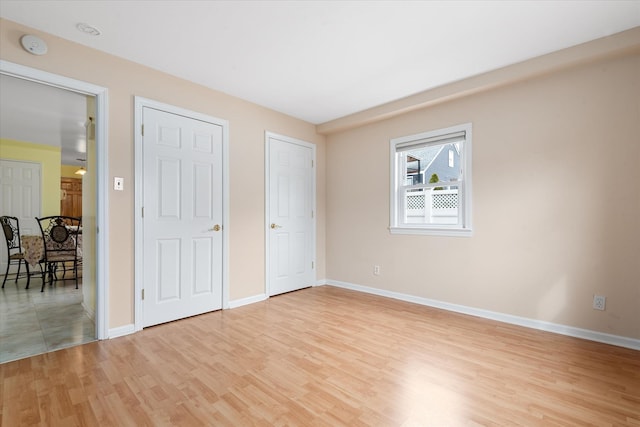 unfurnished bedroom featuring light wood-type flooring and baseboards