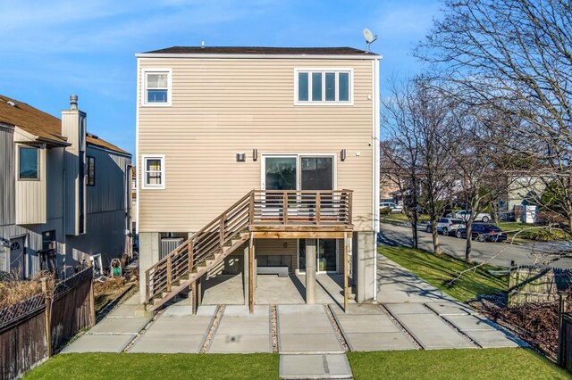 rear view of house featuring a patio, fence, and stairs