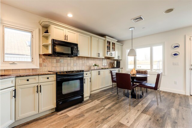 kitchen featuring visible vents, light wood-type flooring, black appliances, and backsplash