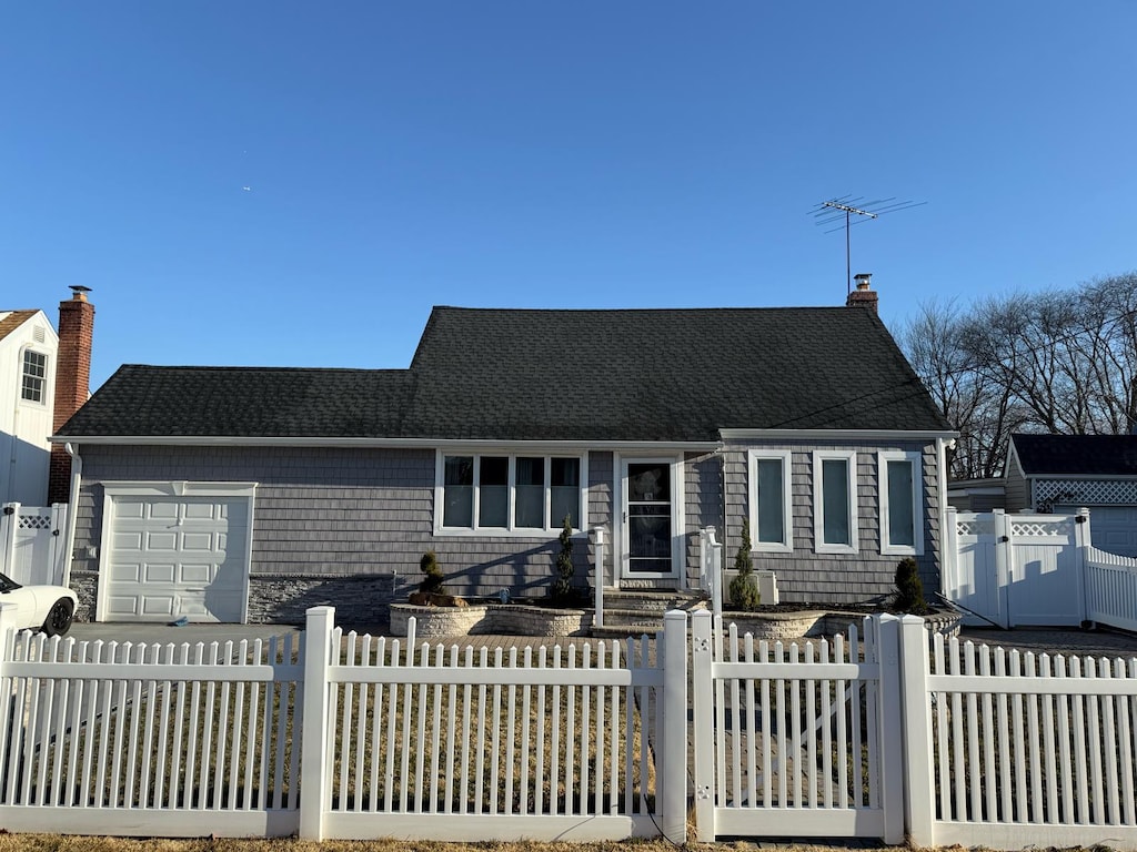 view of front of home with a gate, a fenced front yard, an attached garage, a shingled roof, and a chimney