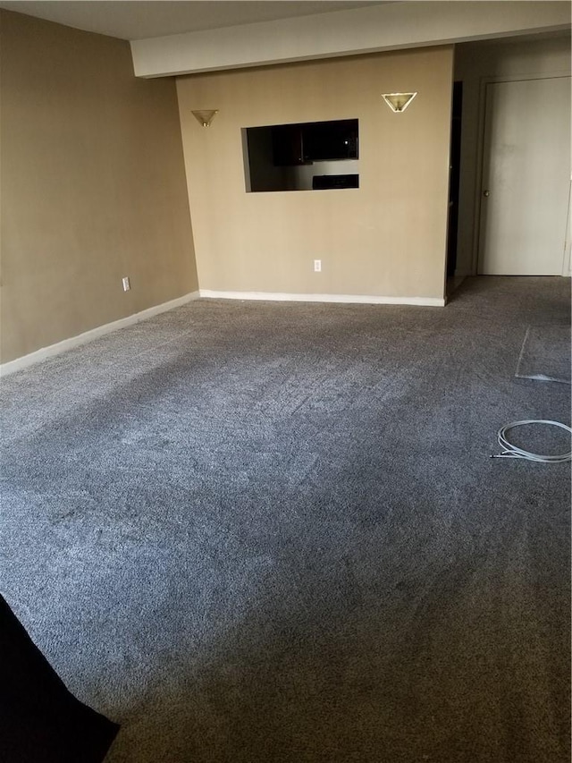 spare room featuring carpet and baseboards