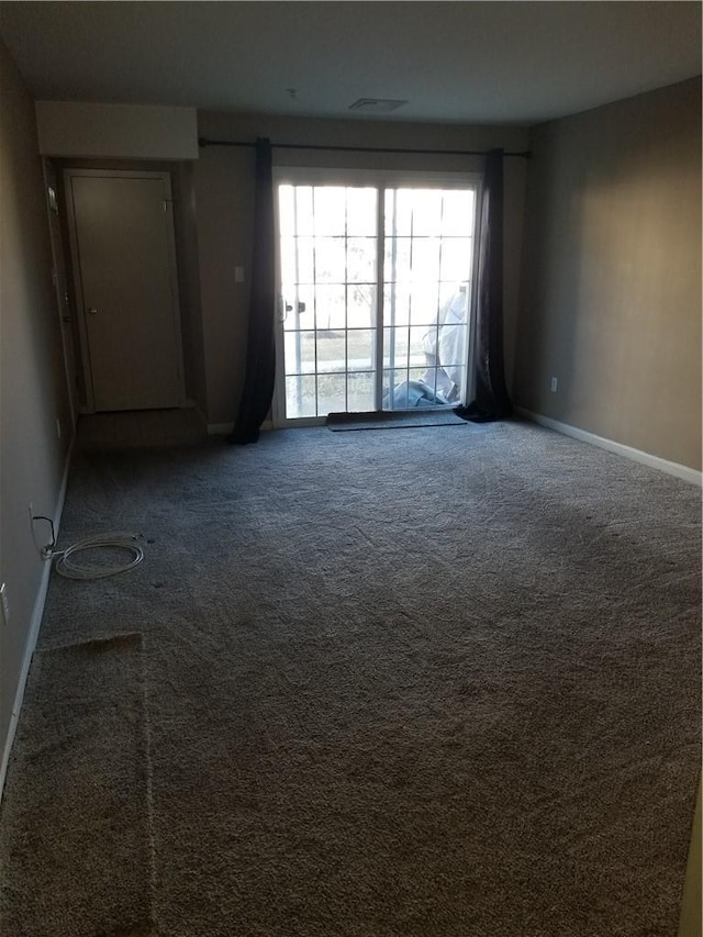 carpeted spare room with visible vents and baseboards