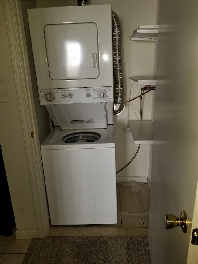 laundry area with laundry area, stacked washer and clothes dryer, and tile patterned floors