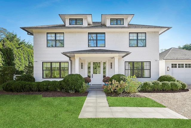 traditional style home featuring covered porch and a front yard