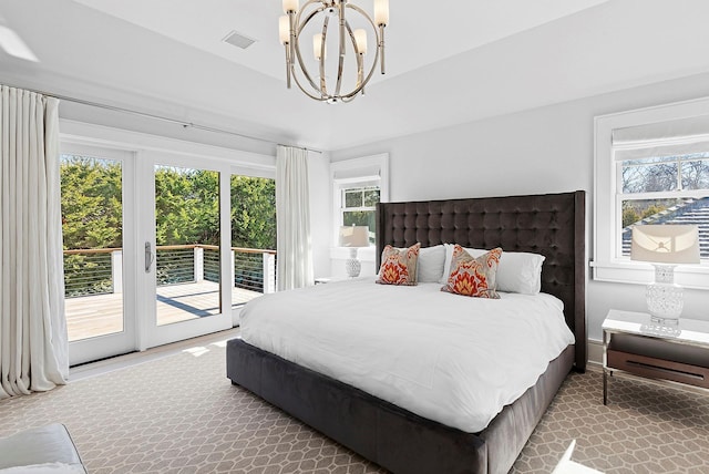 bedroom featuring access to outside, visible vents, and an inviting chandelier