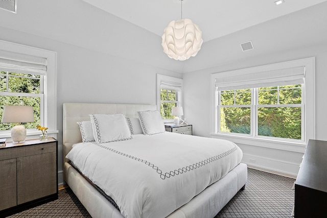 bedroom with an inviting chandelier, visible vents, and baseboards