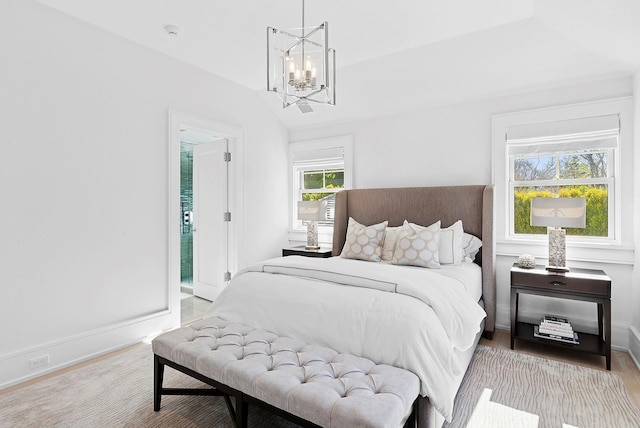 bedroom with lofted ceiling, an inviting chandelier, light wood-style flooring, and baseboards