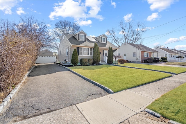 view of front of home featuring an outbuilding, a residential view, a detached garage, and a front lawn