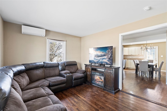 living room featuring a chandelier, dark wood finished floors, and a wall mounted air conditioner