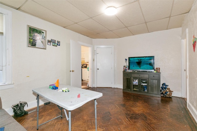 game room featuring a drop ceiling and baseboards