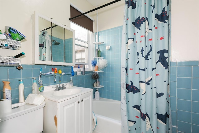 bathroom featuring toilet, shower / tub combo, vanity, and tile walls