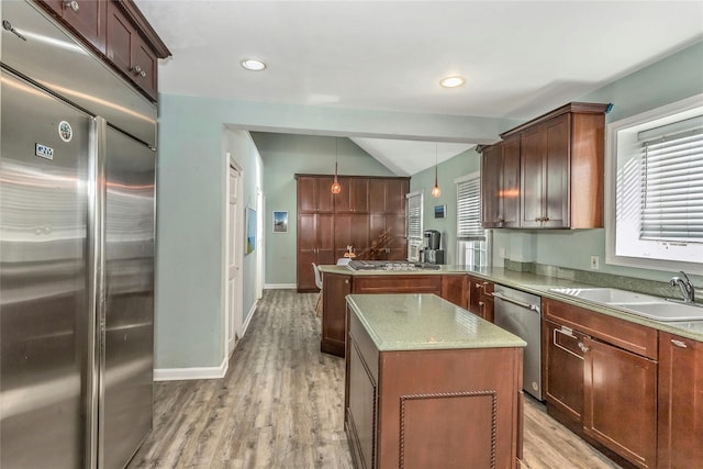 kitchen featuring light wood-style flooring, a kitchen island, stainless steel appliances, a peninsula, and lofted ceiling