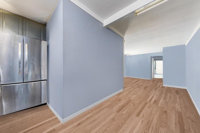 corridor featuring light wood-style floors, ornamental molding, and baseboards