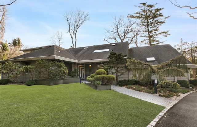 view of front of property with a front lawn and roof with shingles