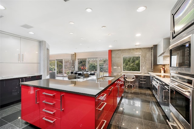 kitchen featuring recessed lighting, granite finish floor, modern cabinets, and oven