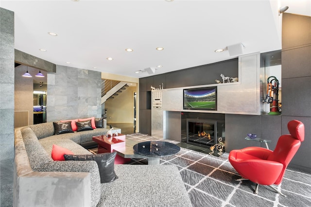 living room featuring a tiled fireplace, stairway, tile walls, and recessed lighting