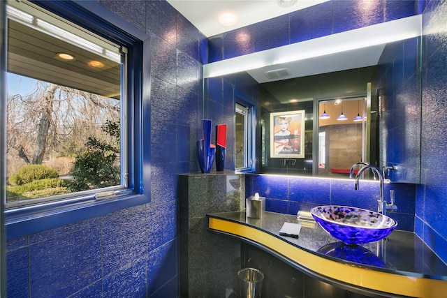 bathroom featuring vanity, backsplash, and visible vents