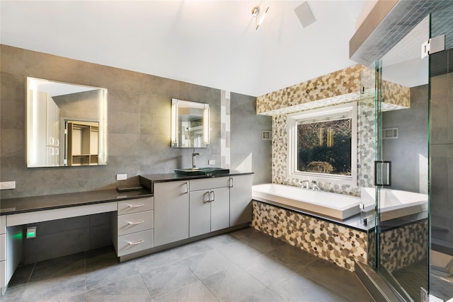 full bathroom featuring a garden tub, tile walls, visible vents, a stall shower, and vanity