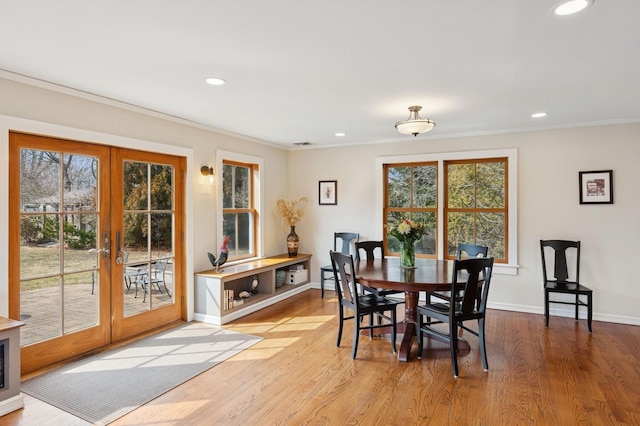 dining space featuring french doors, crown molding, baseboards, and wood finished floors