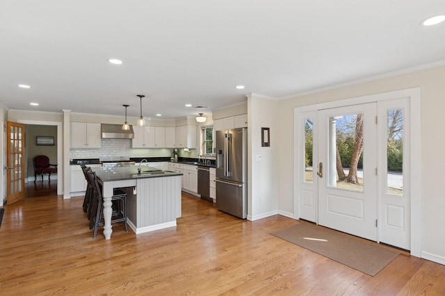 kitchen featuring dark countertops, appliances with stainless steel finishes, and ornamental molding